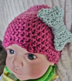 a baby doll wearing a crocheted hat and scarf