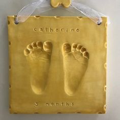 a yellow plaque with two footprints and the words, catherine 3 months