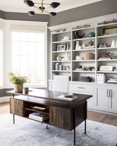 an office with built in bookcases and a large desk on the far wall