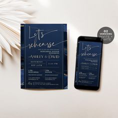 a phone next to a blue and gold wedding card on top of a white table