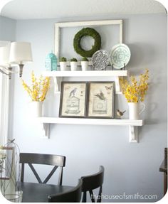 the shelves are decorated with flowers, pictures and wreaths on them for springtime