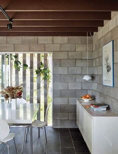 a white table and chairs in a room next to a brick wall with sliding glass doors