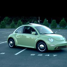 a small green car parked in a parking lot