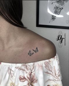 a woman's upper back shoulder with two butterflies on her left shoulder and the lower arm