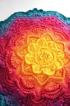 a crocheted blanket with a flower on it