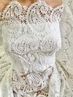 the back of a woman's dress with white lace on it and an open neckline