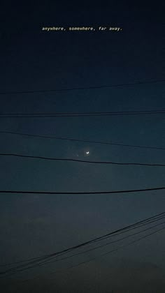 the moon is seen through power lines and telephone poles at night with writing above it