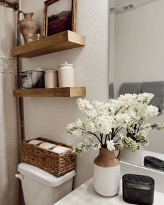 the bathroom is clean and ready to be used as a place for toilet paper, candles, and other items