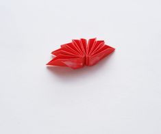 a red origami piece sitting on top of a white surface