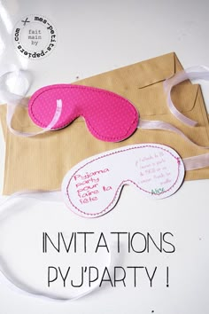 a pair of pink eye masks sitting on top of a piece of paper next to a brown envelope