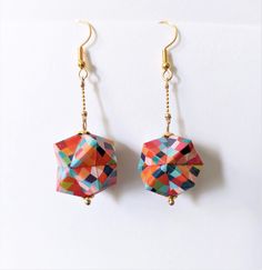 colorful origami earrings hanging from gold earwires on a white background,