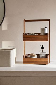 two wooden shelves with soaps, lotion and other items on them in front of a mirror