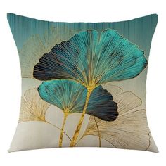 a blue and gold pillow with two large leaves on it