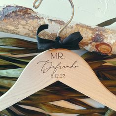 a wooden hanger with a black bow on it that says mr and mrs barack