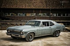 an old station wagon parked in front of a building