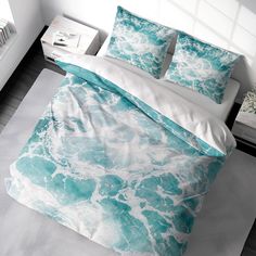 a bed with blue and white comforters on top of it