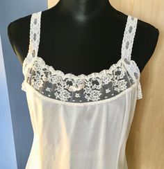 "This white nylon slip by Greenco Maid has lace straps and neckline. There is also lace trim at the hem. The straps are elastic lace but not adjustable. It is a size 38 with these measurements: Bust: 38\" Waist: 36\" Hips: 46\" Shoulder to hem: 40\" Strap length: 6\" Our items are in good condition. Should there be undue wear, something missing or inoperable it will be noted in our text and there will be a photo highlighting such. We add new items regularly and appreciate you taking a look." White Lace Camisole With Spaghetti Straps, Stretch Lace Camisole With Straps, White Camisole With Contrast Lace For Summer, White Lace Camisole With Delicate Straps, White Contrast Lace Camisole For Summer, White Camisole With Delicate Lace And Spaghetti Straps, White Camisole With Contrast Lace, Lace Camisole With Delicate Details For Daywear, White Lace Contrast Camisole