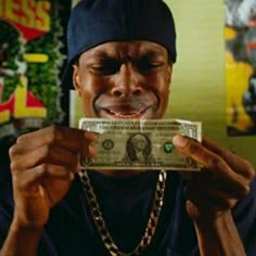 a man holding up a dollar bill in front of his face