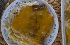 a plate with some food on it next to a fork and glass container filled with liquid