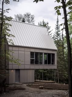 a house in the woods with lots of windows on it's roof and side walls