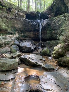 a small waterfall in the middle of a forest