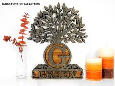 a metal sign that says g is for garden next to two candles and some flowers