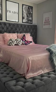 a bed with pink sheets and pillows in a bedroom next to pictures on the wall