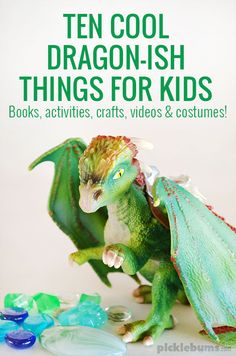 a green toy dragon sitting on top of a table next to plastic bottles and buttons