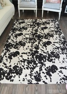 a black and white area rug on the floor in a living room with two chairs