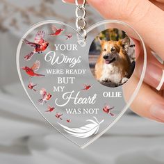 a person holding a heart shaped keychain with a dog and butterflies on it