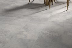 a table and chairs in a room with tile flooring that looks like it has been cleaned