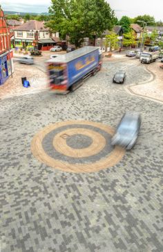 a blue truck driving down a street next to tall buildings