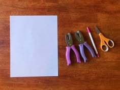 three pairs of scissors next to a piece of paper on a table with other tools