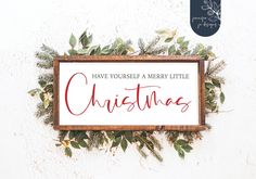 a wooden sign that says have yourself merry little christmas with greenery around it on a white wall