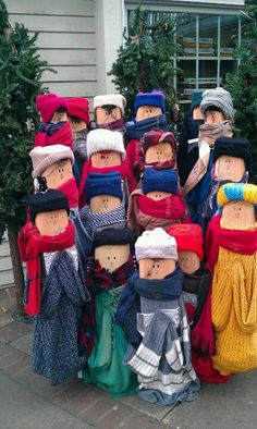 a group of people with hats and scarves on their heads standing in front of a building