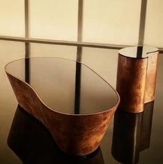 two glass and wood vases sitting on a table