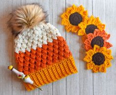 two crocheted sunflowers are next to a knitted hat