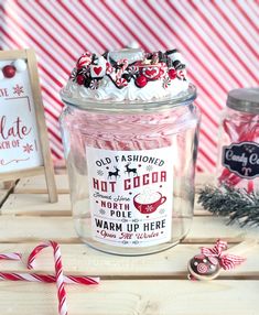 a jar filled with candy canes sitting on top of a table next to other items