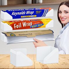 a woman is holding three rolls of toilet paper in front of some boxes on the table