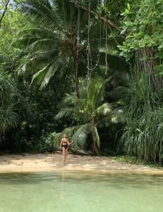 a woman is standing in the middle of a pool surrounded by trees and greenery