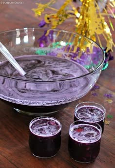 three glasses filled with liquid sitting on top of a wooden table