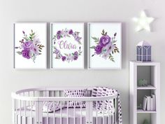 a baby's room with pink and purple flowers on the wall, two framed pictures above a crib