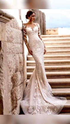 a woman in a wedding dress standing on some steps