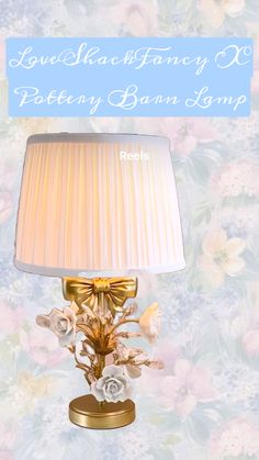 a lamp that is sitting on top of a table next to a flowery wallpaper