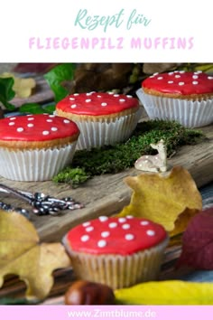 cupcakes with red frosting and white polka dots are on a wooden board