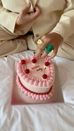 a person is cutting into a pink cake