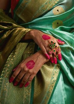 a woman with her hands painted in red and green colors, holding onto the hand of another person's arm