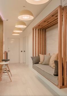 a living room filled with lots of furniture and wooden accents on the walls, along with round lights