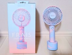 a pink and blue fan sitting next to a box