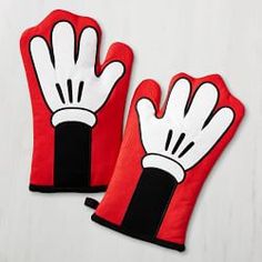 two red oven mitts with black and white designs on them sitting on a table